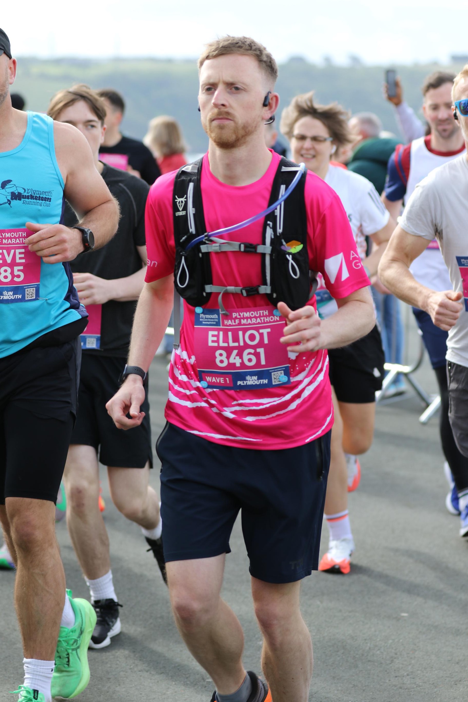 Elliot running the Plymouth Half Marathon in a bright pink race shirt